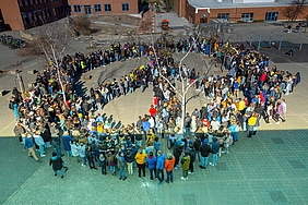 Schüler der Europaschule formen auf dem Schulhof ein großes Peace-Zeichen.