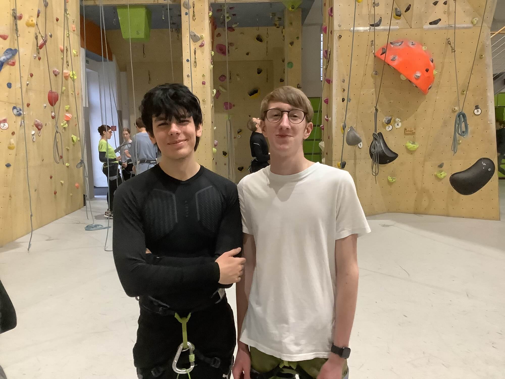 Zwei Schüler mit Klettergurt in der Kletterhalle Bergwerk.