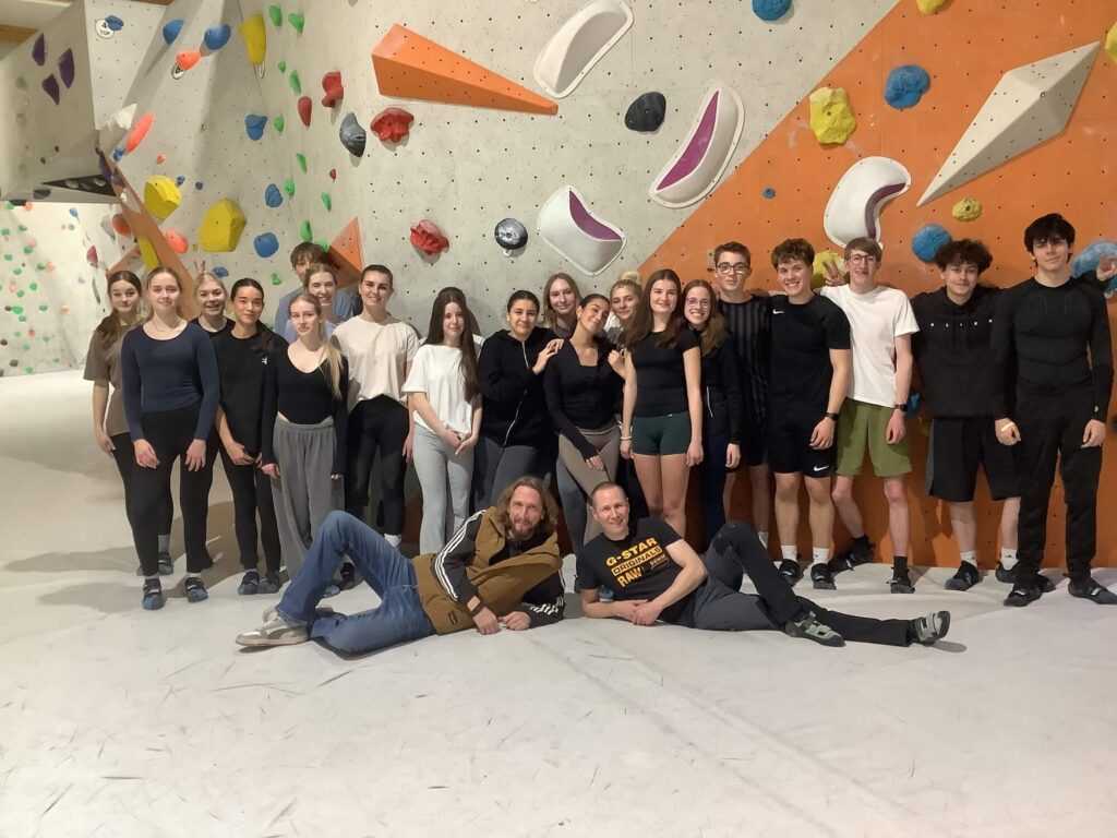 Gruppenfoto der Schüler und Lehrkräfte vor einem Boulder.