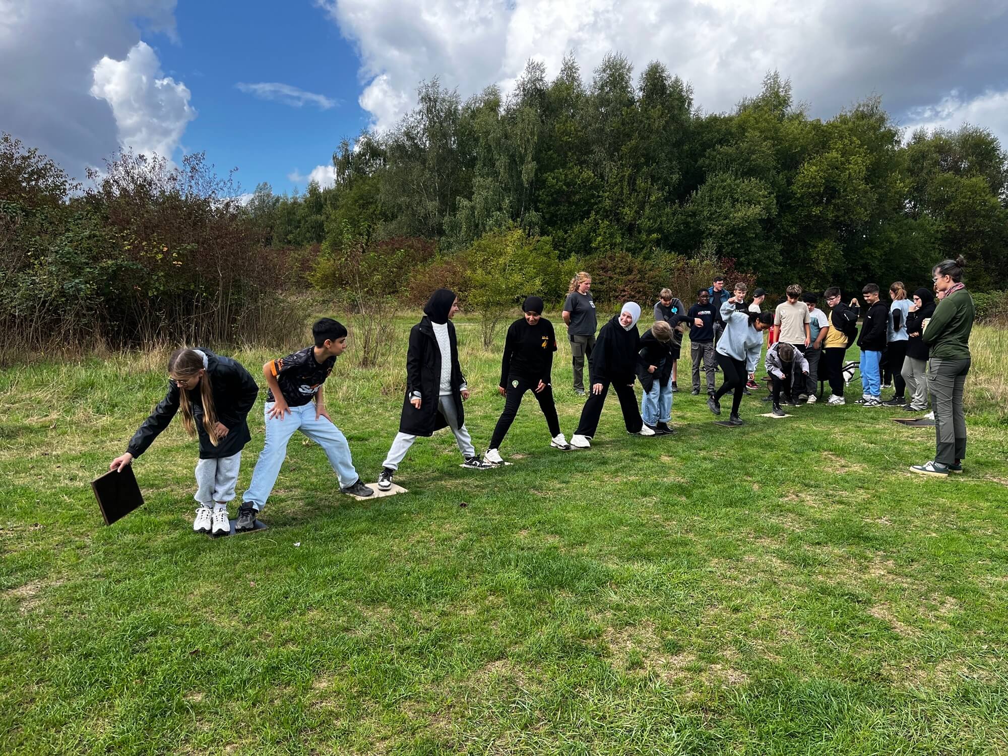 Schüler bei einem kooperativen Spiel auf einer Wiese.